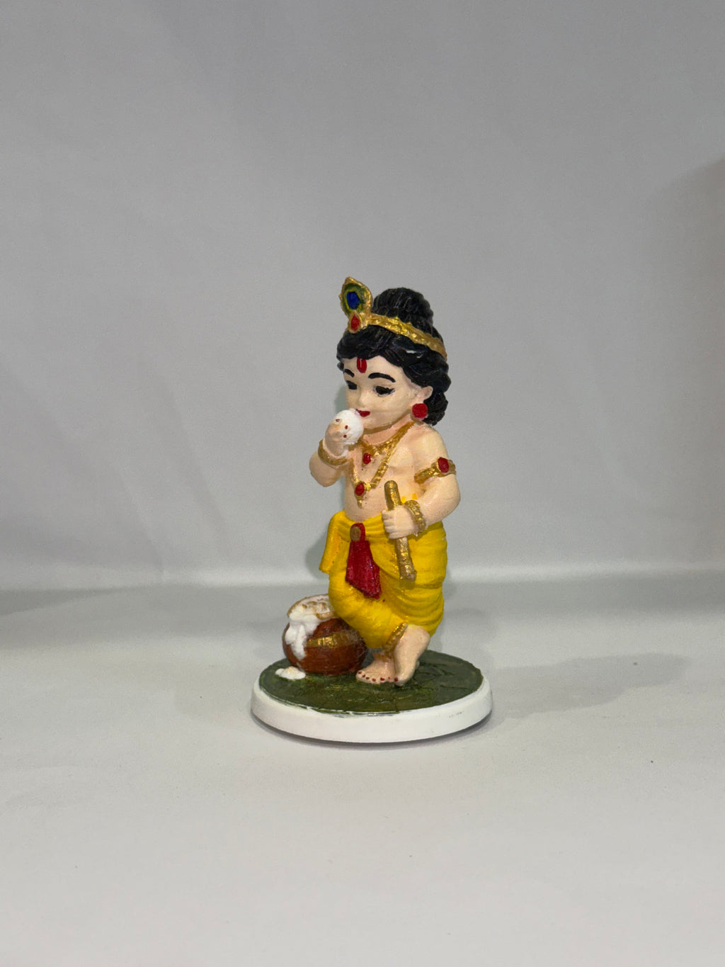 Captures the classic, beloved "Makhan Chor" pose—complete with the traditional pot of butter (matki), flute, and peacock feather crown.