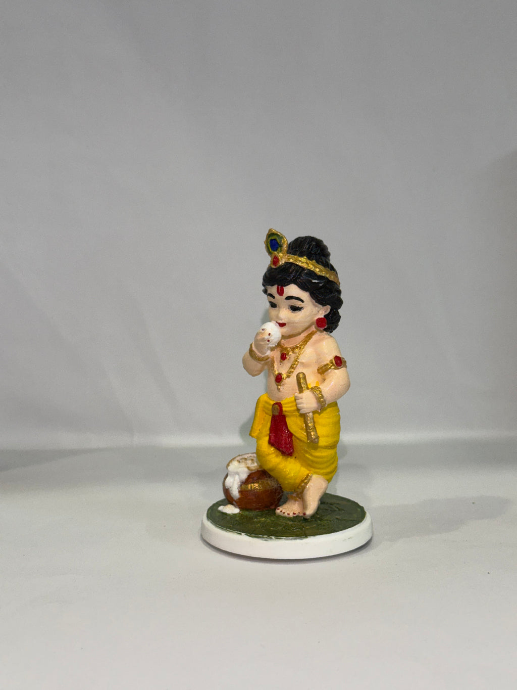 Captures the classic, beloved "Makhan Chor" pose—complete with the traditional pot of butter (matki), flute, and peacock feather crown.